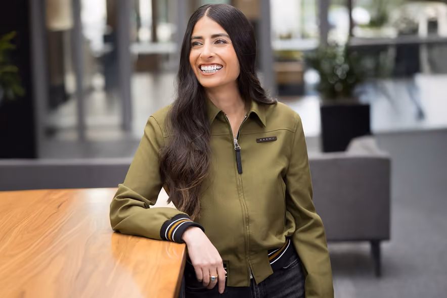 Portrait officiel d’Asha Sharma, souriante en veste sombre sur fond neutre.